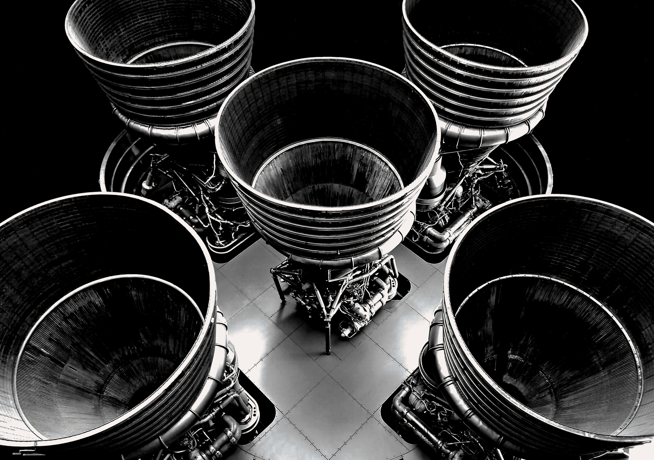 Rocket engine nozzles seen from below in stark black and white.