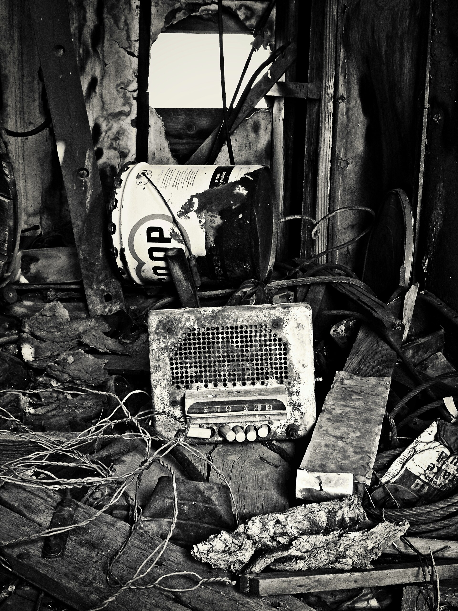 An old radio among tangled debris in an abandoned room.