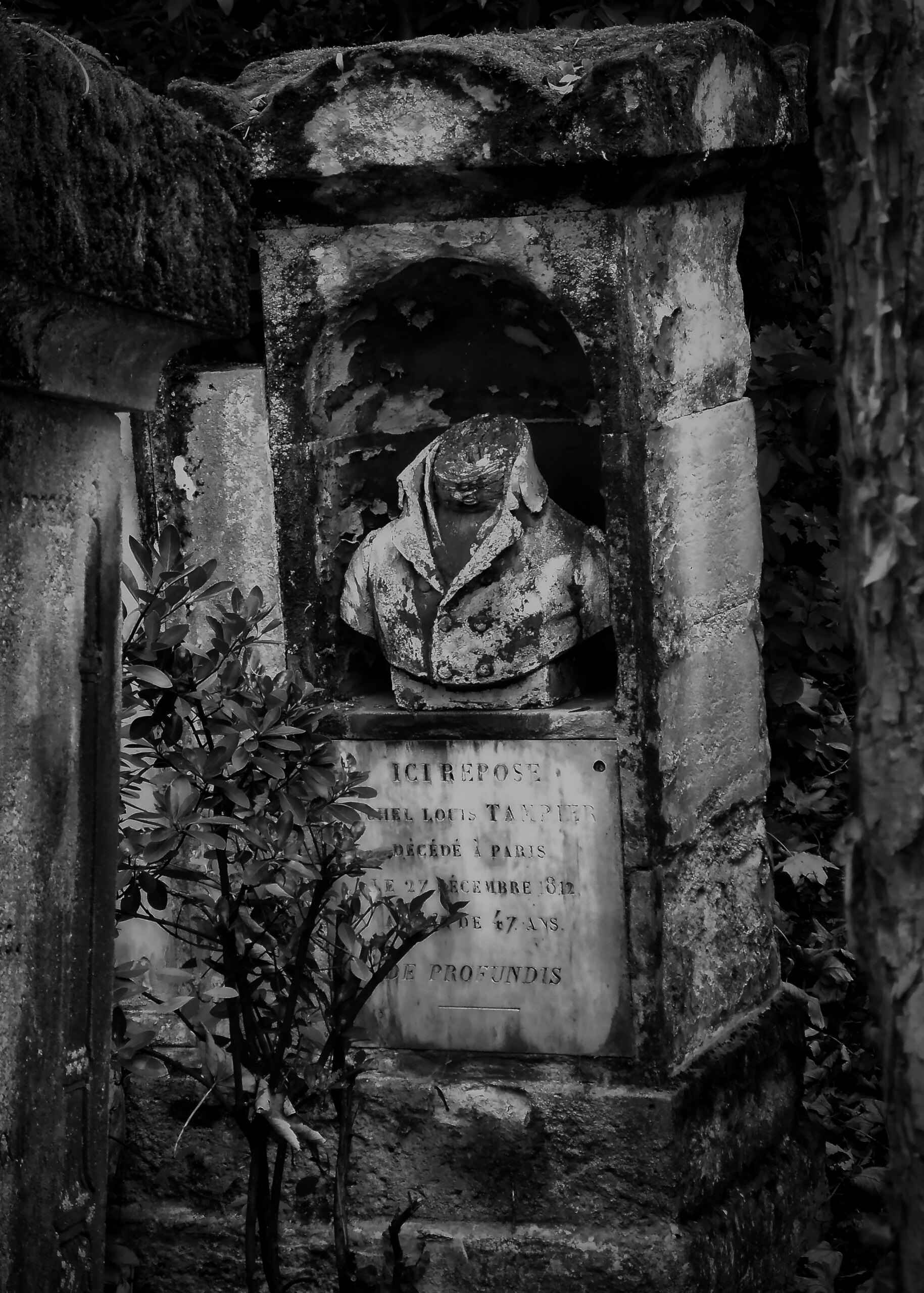 A carved stone memorial set in a crumbling wall niche.